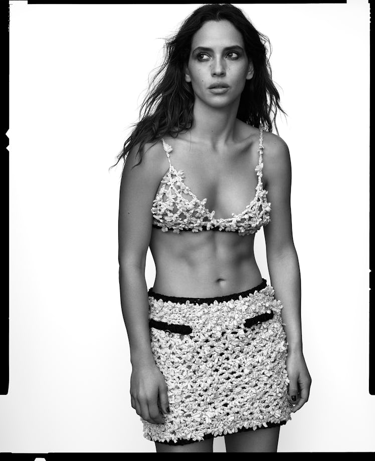 Adria Arjona wears a Chanel bra top and skirt.