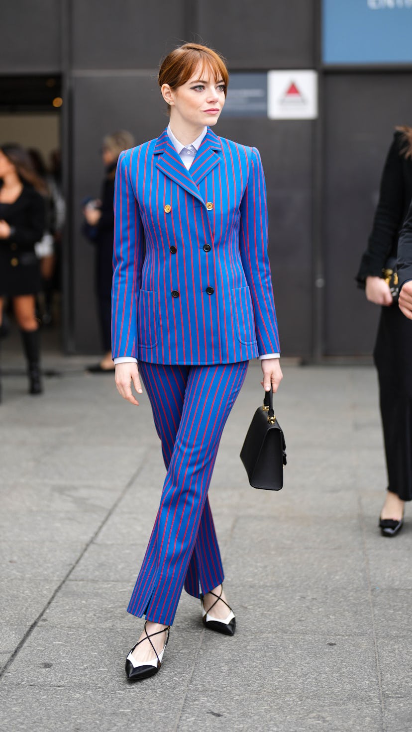 PARIS, FRANCE - MARCH 06: Emma Stone wears a white shirt, a royal blue with small red striped print ...