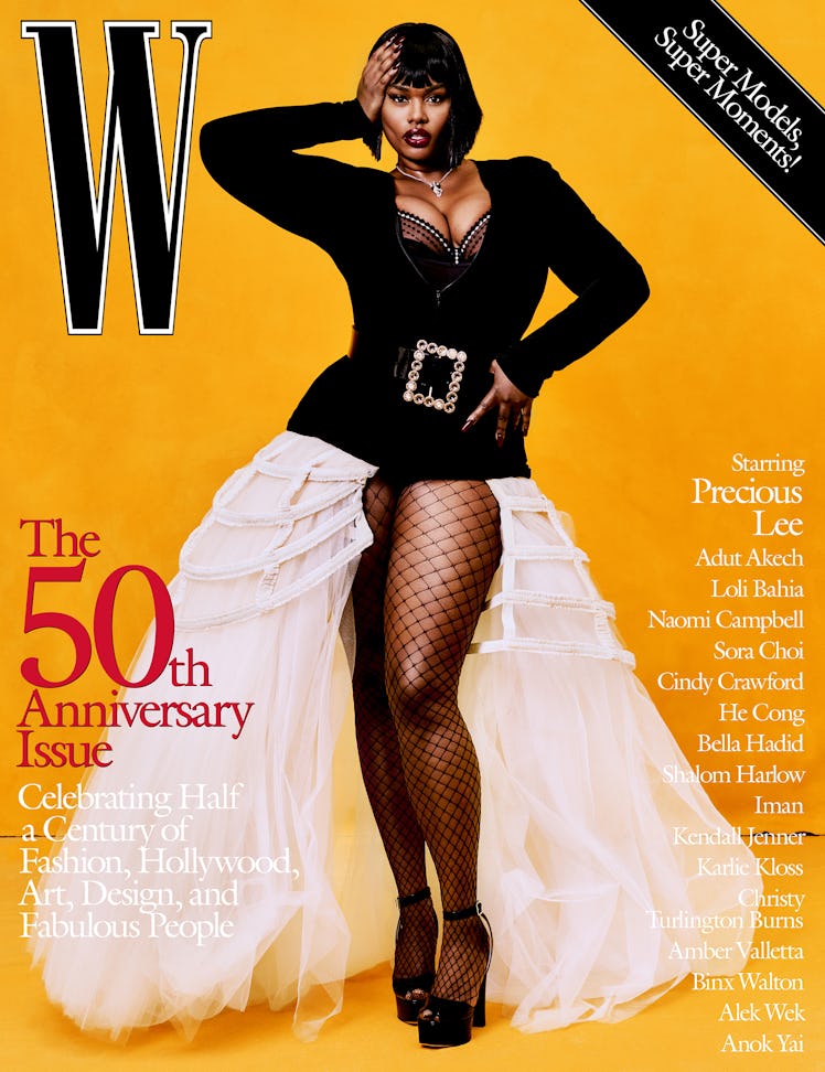 Precious Lee in a black top with a huge belt, white skirt, and fishnets on the cover of W Magazine's...