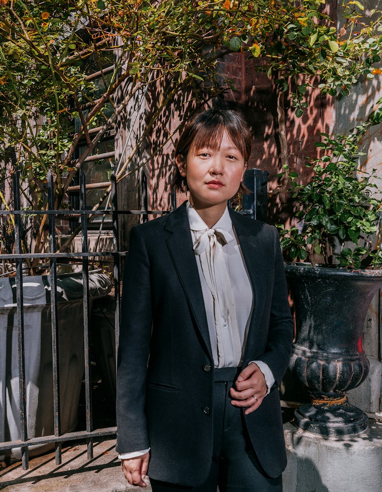 Celine Song wears a Celine by Hedi Slimane jacket, shirt, and pants.