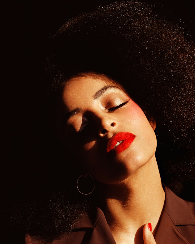 a woman wearing red lipstick with her eyes closed